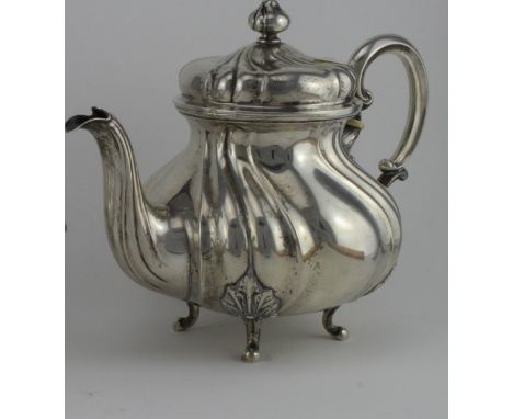 German silver teapot, lobed baluster form, scroll handle, domed cover on four bracket feet. Length handle to spout 25½ cms.  