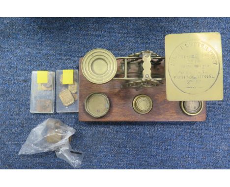 A set of brass 'Inland Letter Post' postal scales mounted on an oak plinth, with a quantity of various weights