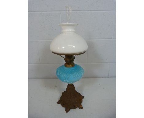 Oil Lamp with frosted shade and clear chimney and blue glass well, moulded with scrolls. Standing on a cast metal base