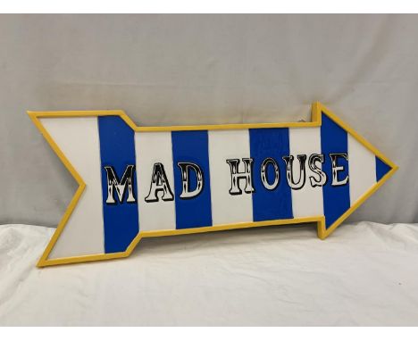 APAINTED SIGN IN THE SHAPE OF AN ARROW WITH THE WORDS 'MAD HOUSE' 82CM X 32CM 