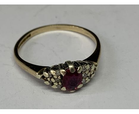 A 9 CARAT GOLD RING WITH A SOLITAIRE RUBY AND DIAMONDS TO THE SIDE SIZE J/K 