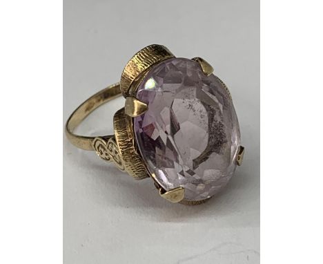 A 9 CARAT GOLD RING WITH A LARGE PALE PURPLE COLOURED STONE SIZE Q IN A PRESENTATION BOX 