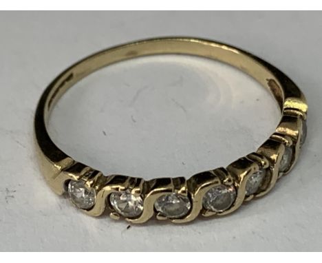 A 9 CARAT GOLD RING WITH SEVEN IN LINE CLEAR STONES IN A PRESENTATION BOX 