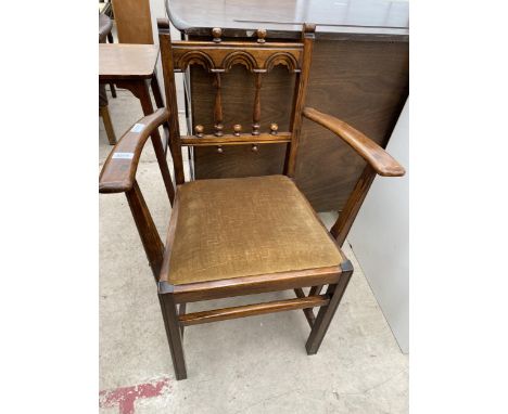 AN ERCOL ELBOW CHAIR WITH ARCHED BACK, HAVING TURNED UPRIGHTS 