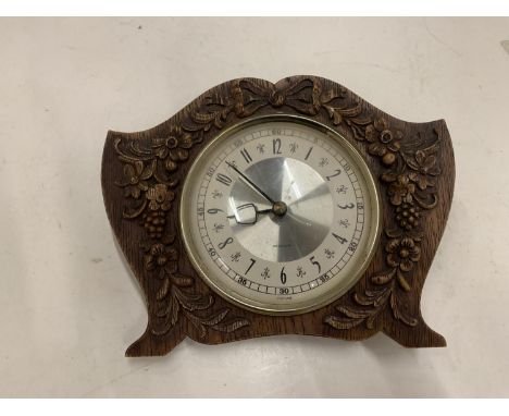 A WOODEN WESTCLOX MANTLE CLOCK WITH A FLORAL CARVED FRONT 