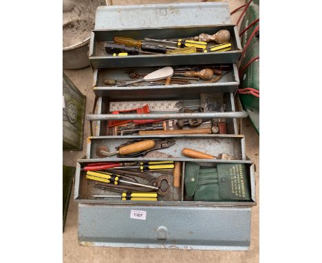 A METAL TOOL BOX CONTAINING AN ASSORTMENT OF TOOLS TO INCLUDE STILSONS, SCREW DRIVERS AND A RASP ETC 