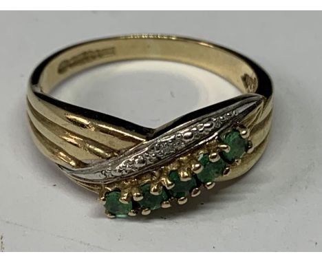 A 9 CARAT GOLD RING WITH DIAMONDS AND EMERALDS IN A TWIST DESIGN SIZE M IN A PRESENTATION BOX 