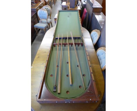 A Victorian mahogany folding bagatelle board and accessories