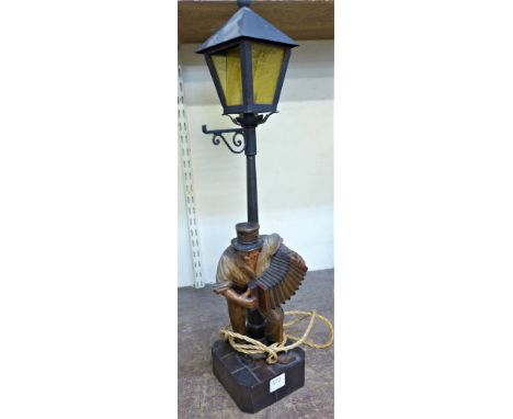 A carved figural table lamp