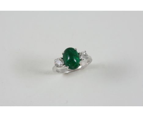 AN EMERALD AND DIAMOND THREE STONE RING the oval cabochon emerald weighs approximately 2.50 carats and is set with two circul