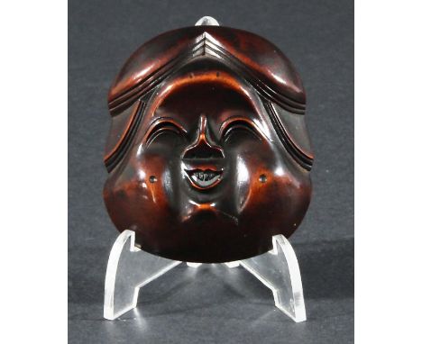 JAPANESE WOOD NETSUKE, carved as a mask of Okame, signed Gyokusho, height 7cm Provenance: Illustrated Lazanick (G), Netsuke a