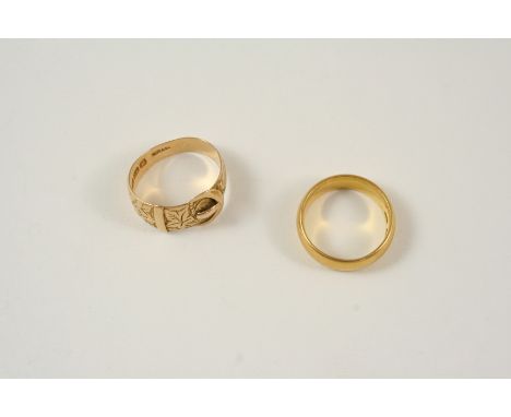 AN 18CT. GOLD BUCKLE RING with foliate engraved decoration, 4.1 grams, size K, together with a 22ct. gold wedding band, 6.9 g