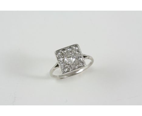 A DIAMOND PLAQUE RING centred with an old brilliant-cut diamond within a surround millegrain set with graduated old brilliant