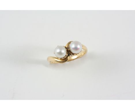 A PEARL AND GOLD CROSS-OVER RING set with two untested pearls, in gold. Size K 1/2.