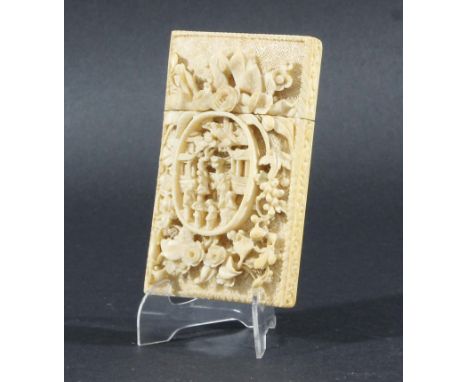 CHINESE IVORY CARD CASE,  19th century, the front carved in deep relief with a central oval cartouche of figures inside a flo