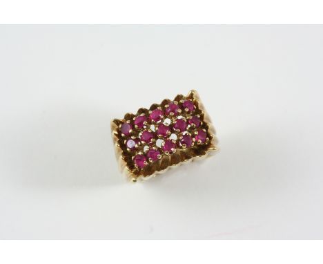 A RUBY RING formed as three rows of circular-cut rubies in gold. Size I.