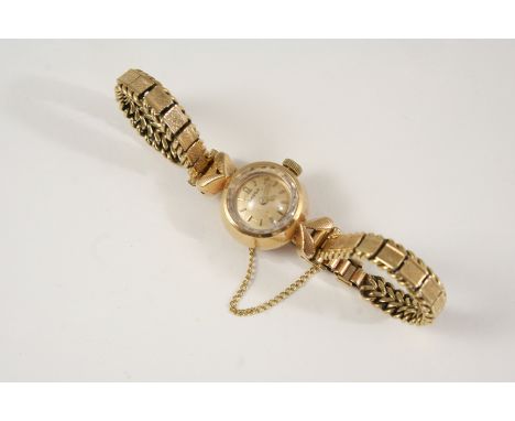 A LADY'S  9CT. GOLD WRISTWATCH BY OMEGA the signed circular dial with baton numerals, on a 9ct. gold bracelet with ladder cla
