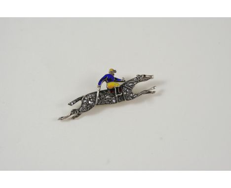 A DIAMOND AND ENAMEL HORSE AND JOCKEY BROOCH the galloping horse set with rose-cut diamonds, the jockey with blue and yellow 