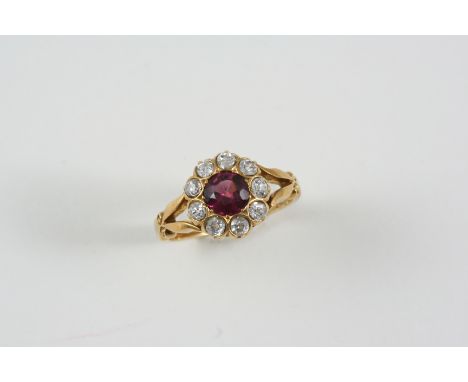 A GARNET AND DIAMOND CLUSTER RING the circular-cut garnet is set within a surround of old brilliant-cut diamonds, in 18ct. go