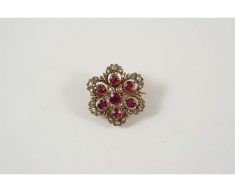 A VICTORIAN RUBY AND DIAMOND BROOCH PENDANT the flowerhead design is set with rose-cut diamonds and circular rubies, in gold,