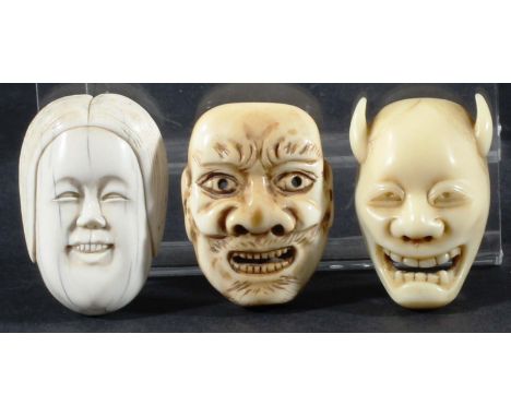 TWO JAPANESE IVORY NETSUKE, carved as grinning masks, one signed; together with another mask of an oni, signed (3)