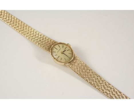 A LADY'S 9CT. GOLD WRISTWATCH BY LONGINES the signed oval-shaped dial with baton numerals, on a 9ct. textured gold integrated