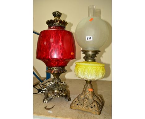 A CAST METAL SINGLE BURNER OIL LAMP, having yellow pressed glass reservoir and crackle style opaque glass shade, standing on 