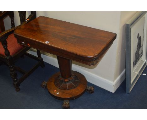 AN EARLY VICTORIAN ROSEWOOD FOLDOVER CARD TABLE, with rounded corners, circular green baize lined interior, on an inverted co