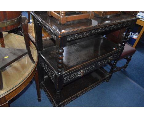 AN EARLY 20TH CENTURY CARVED OAK THREE TIER BUFFET, with a carved raised back joined by bobbin turned front supports, two cen