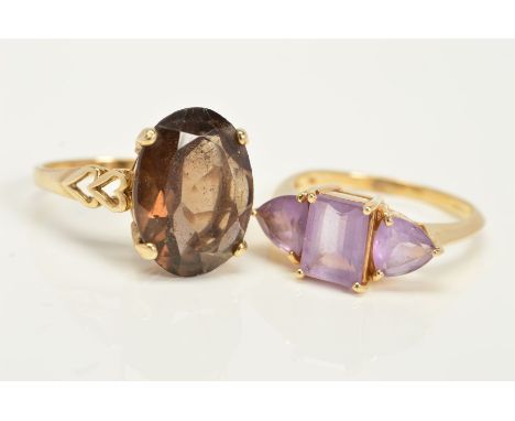 TWO GOLD GEM SET RINGS, the first a 9ct gold ring set with a central oval smokey quartz and open heart shape shoulders, with 