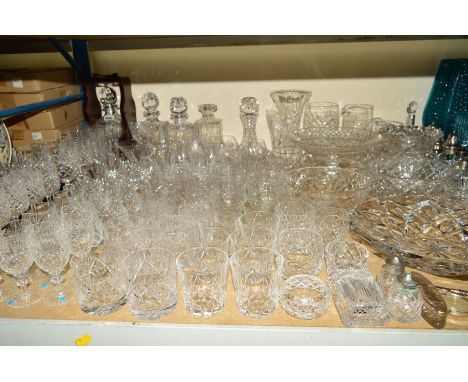 A COLLECTION OF UNMARKED CUT GLASS including one bottle tantalus, four decanters, six champagne flutes, four wine glasses, te