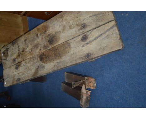 AN 18TH CENTURY AND LATER ELM PIGS BENCH on later legs (broken leg joints)