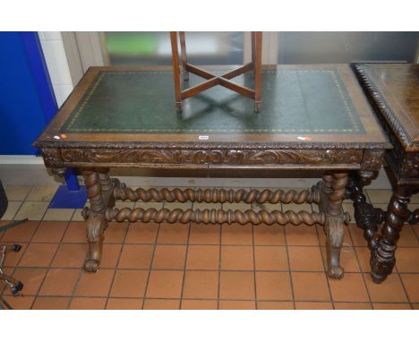 A LATE 19TH/EARLY 20TH CENTURY CARVED OAK SIDE TABLE, with a green tooled leather top, two drawers on barley twist upright un