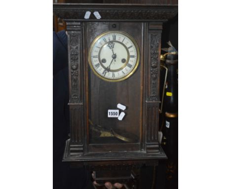 AN EARLY 20TH CENTURY OAK WALL CLOCK with an enamel dial and Roman numerals (winding key)