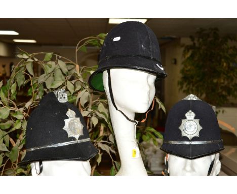 THREE EXAMPLES OF POLICE STYLE HELMETS, two have copy style Police Officer badges attached in metal, one rosette top, the oth