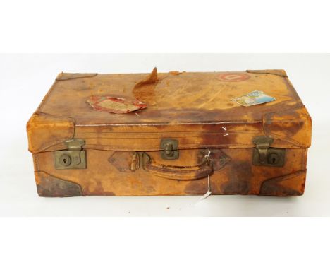 Vintage leather suitcase with various shipping labels, including RAF and Cunard 
