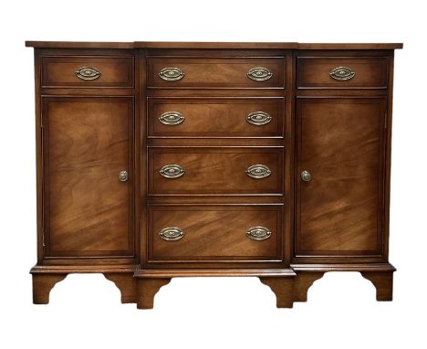 Walnut breakfront side cabinet, the breakfront top over four graduated drawers, flanked by two cupboards and two drawers, rai