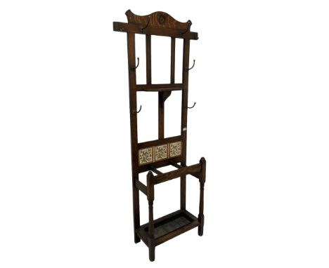Edwardian oak hallstand, fitted with one bevel edged mirror, surrounded with hooks for hanging over floral tiles and drip tra