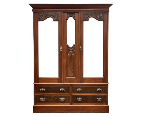 Edwardian figured walnut double wardrobe, enclosed by bevelled mirror glazed doors with foliate carvings, fitted with four dr