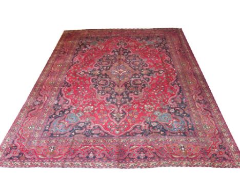 TABRIZ CARPET, 380cm x 300cm, pendant medallion on a ruby field of vines, flowerheads and botehs within midnight blue spandre