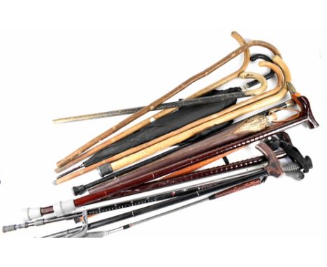 A quantity of walking canes to include one with white metal collar and horn handle, a vintage gentlemen's black umbrella and 