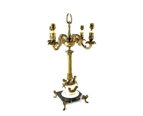 A table lamp in the form of an Empire-style gilt metal four-branch candelabrum, with Corinthian column, on a square marble ba