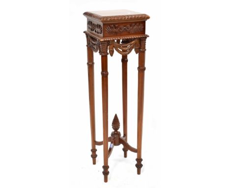 A reproduction mahogany jardinière stand, the square top with gadrooned edge, floral and foliate carved motifs and swags, on 