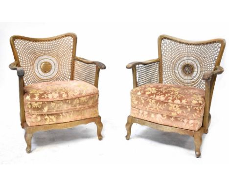 A pair of 1930s bergère armchairs with floral upholstered overstuffed seats, on cabriole legs (2).  CONDITION REPORT First ch