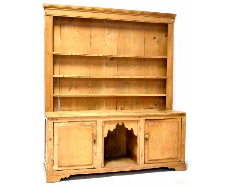 A Victorian pine dresser, the enclosed plate rack with three shelves above a base with open pot cupboard flanked by a pair of