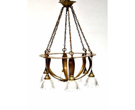 An Arts &amp; Crafts brass ceiling light with six light fittings with glass shades, on a circular frame with basket-form bran