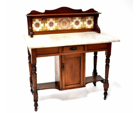 An Edwardian mahogany wash stand with marble top and tiled gallery above a base with cupboard and stretcher, on turned legs, 