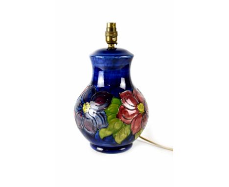 A Moorcroft table lamp of baluster form, cobalt blue ground with clematis pattern, impressed marks to base and remnants of pa