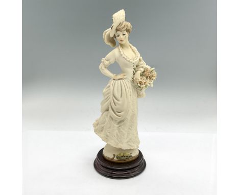 Cream colored matte figure of a lady in a long dress holding a basket of roses. Florence affixed label. This item has its ori