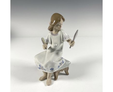 A young girl sitting on a tufted bench holding a mirror and brush. Gloss finish. This item has its original box, 9"L x 10"W x